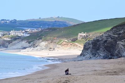 Scenic view of beach against sky with people in the distance 