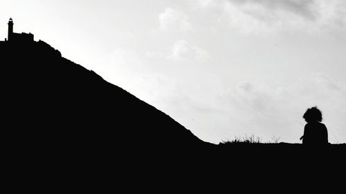 Silhouette man looking at mountain against sky