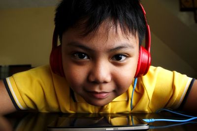 Close-up of boy listening to headphones while using smart phone