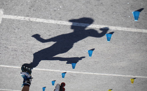 Low section of man inline skating on street during summer