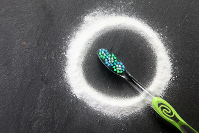 High angle view of baking soda with toothbrush on table