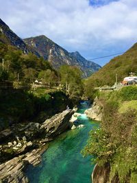 Scenic view of river amidst mountains against sky