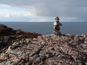 Scenic view of rocks on beach against sky