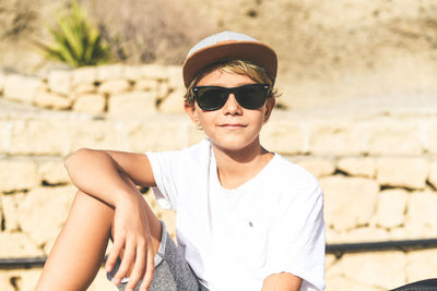 Portrait of boy wearing sunglasses against wall