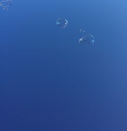Low angle view of moon in blue sky