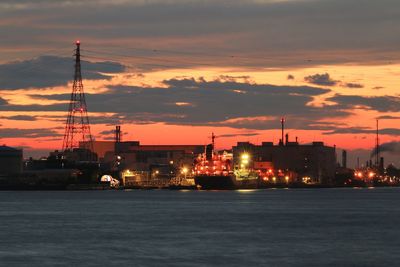 Illuminated commercial dock against sky at sunset