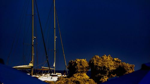 Sailboat by sea against clear blue sky