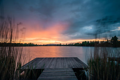 Scenic view of lake against sky at sunset