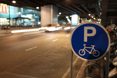 Road sign on street in city at night