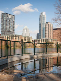 Bridge over river in city against sky