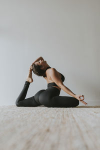 Female instructor with eyes closed practicing yoga at studio