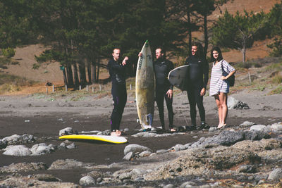 People standing on land against trees
