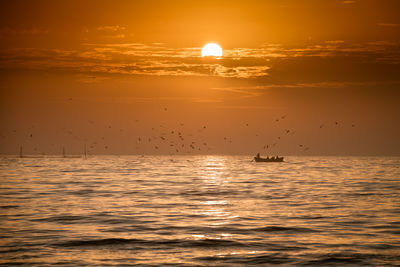 Scenic view of sea against orange sky