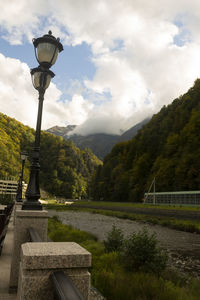 Street light by mountains against sky