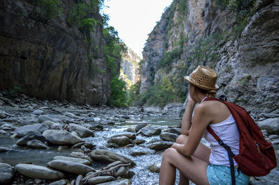 Woman looking at rock formation in water