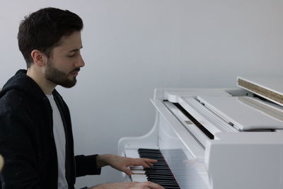 Side view of young man looking at camera