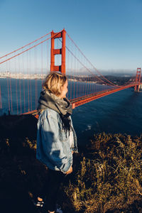 Woman standing against golden gate bridge