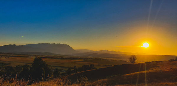 Scenic view of field against sky during sunset