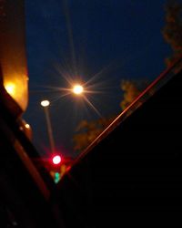 Low angle view of illuminated lights against sky at night