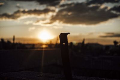 Silhouette of wooden post against sky during sunset