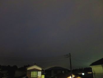 Low angle view of illuminated buildings against sky at night