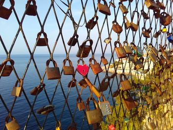 Close-up of padlocks on railing against sea