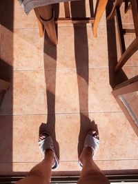 Low section of woman standing on tiled floor