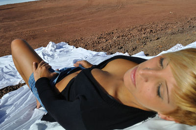 Sensuous woman lying down at sandy beach