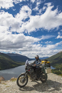 Motorbike rider stops in front of lake on ruta 3 in tierra del fuego