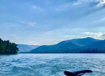 Scenic view of sea by mountains against sky
