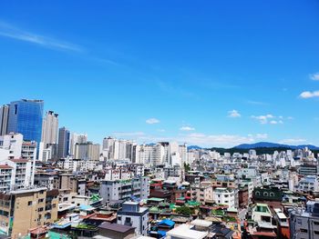 High angle view of buildings against blue sky