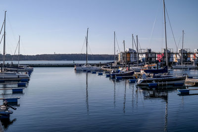 Boats moored at harbor against sky