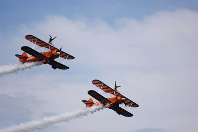 Low angle view of airplane in mid-air against sky