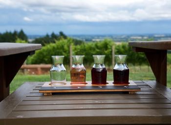 Close-up of drink in glasses on wooden table against sky