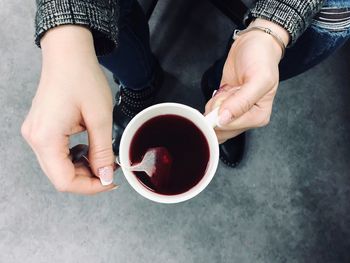 Midsection of man holding coffee cup on table