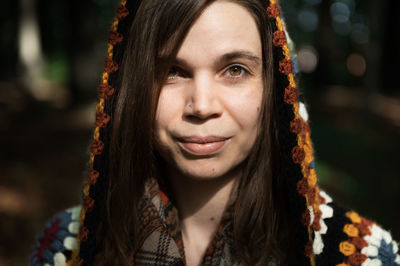 Close-up portrait of smiling young woman in crochet sweater