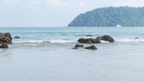 Scenic view of rocks in sea against sky