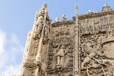 Low angle view of statues on building against sky