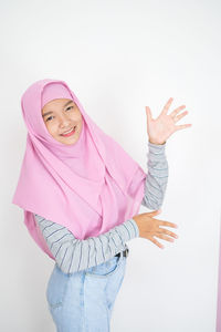 Portrait of a smiling young woman against white background