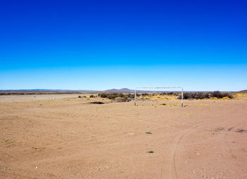 Scenic view of desert against clear blue sky