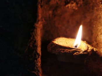 Close-up of illuminated light candle against black background