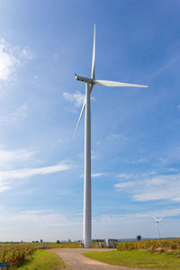 Low angle view of windmill on field against sky