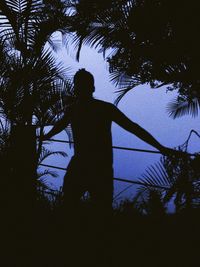 Silhouette man standing by tree against sky