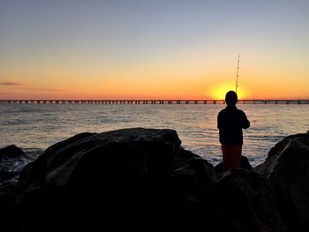 Man standing on beach at sunset