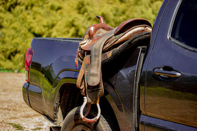 Western horse saddle on pickup truck. ranch life with horse tack. 