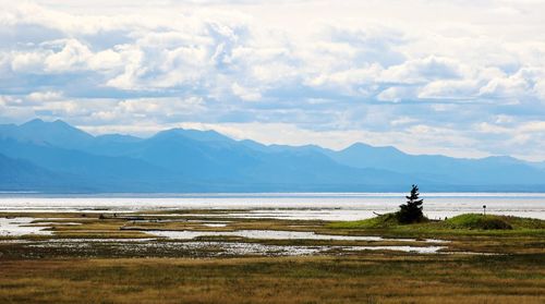 Scenic view of sea and mountains against sky