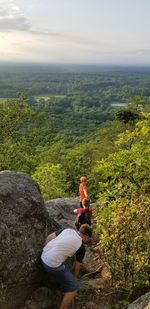 People on rock against mountains