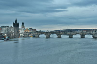 Arch bridge over river against buildings