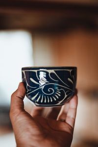 Close-up of hand holding coffee cup