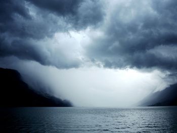 Scenic view of sea against storm clouds